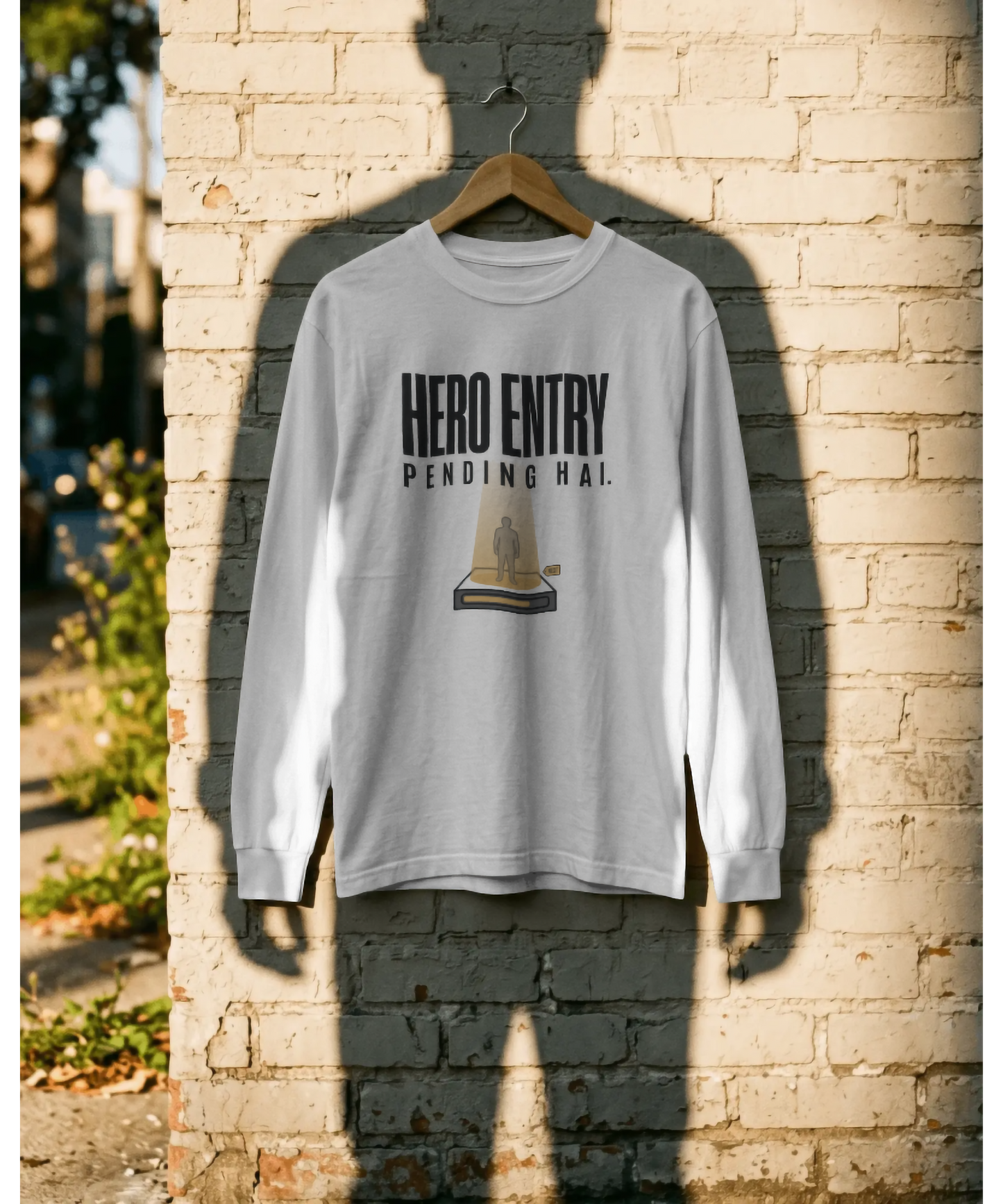 White unisex graphic t-shirt featuring the Hindi text "Hero Entry Pending Hai." The design includes a creative illustration of a person standing in a glowing teleportation beam. Premium pop-culture and cinematic streetwear by The Nite Stream.