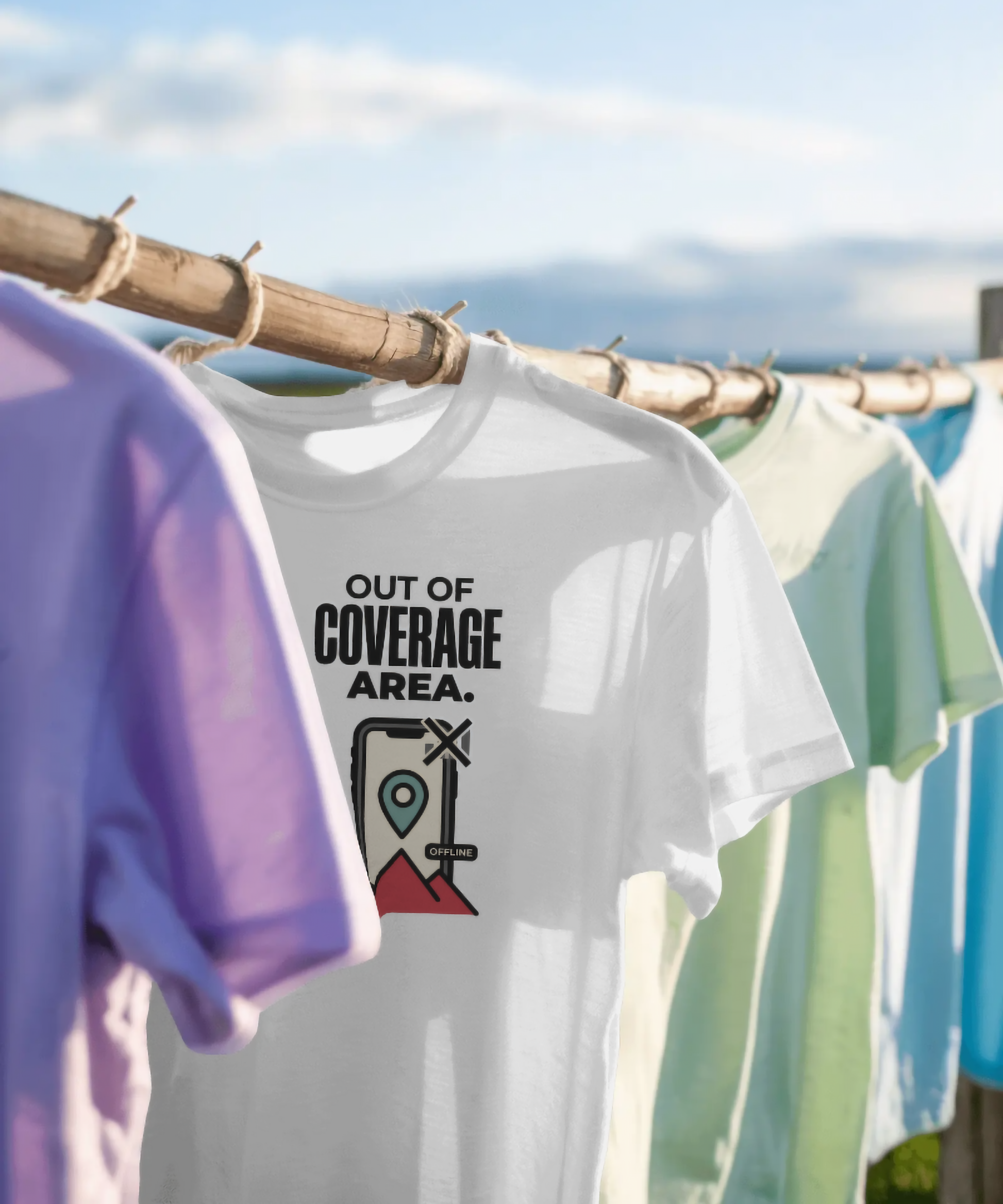 White unisex graphic t-shirt featuring the text "OUT OF COVERAGE AREA." The design includes a creative illustration of a smartphone displaying an offline map pin over mountains. Premium travel, trekking, and digital detox streetwear by The Nite Stream.