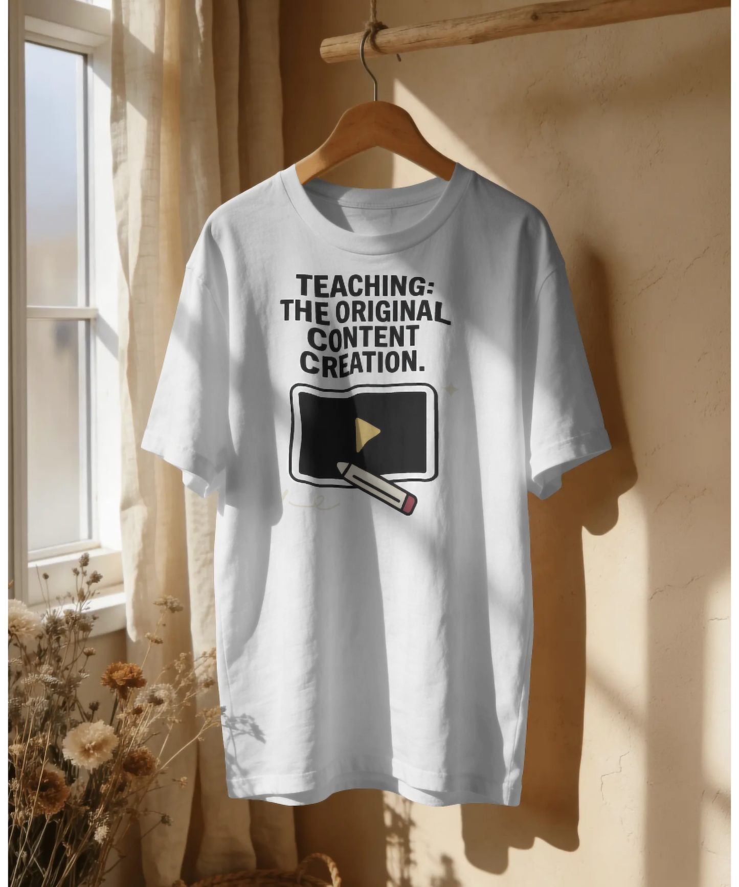 White premium unisex t-shirt by Nite Stream featuring a smart graphic of a video play button being drawn by a pencil, with bold typography reading 'TEACHING: THE ORIGINAL CONTENT CREATION.'