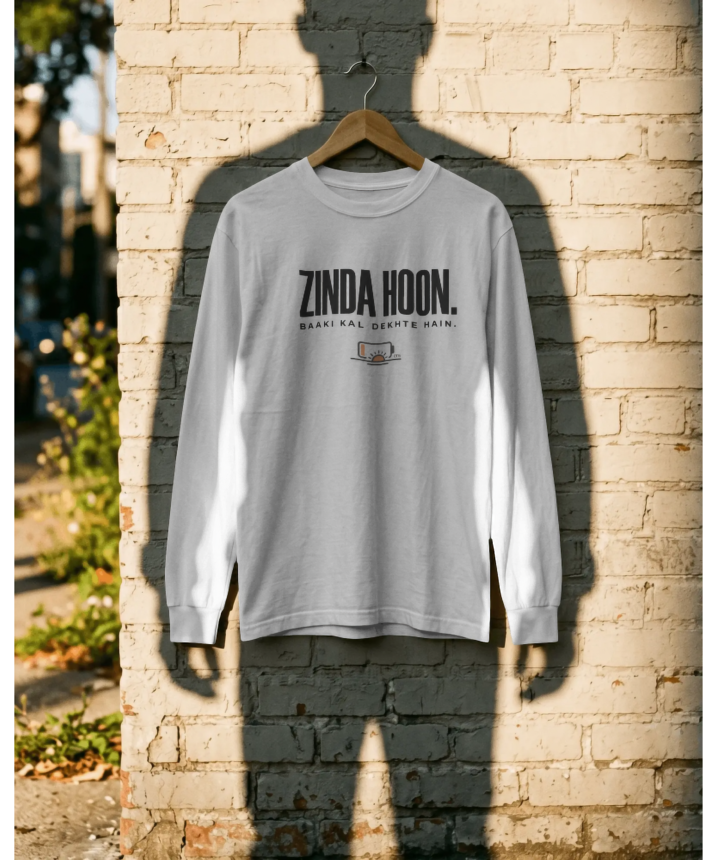 White unisex graphic t-shirt featuring the Hindi quote "Zinda Hoon. Baaki Kal Dekhte Hain." in bold typography with a low battery icon. Premium casual streetwear for relaxing and unwinding, by The Nite Stream.